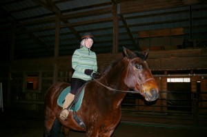Marilee riding horse named Balboa in the arena at Cat Hollow Farm.