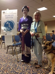 A costumed geisha girl poses with guide dog Geisha and Marilee. Marilee is a volunteer at the disability services desk at DragonCon 2012.