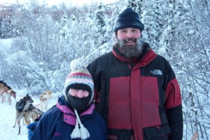 In photo. Marilee is dwarfed by our musher who is a burly young fellow over 6 feet tall. End photo.
