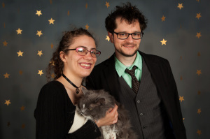 In photo. Seth and Jess in a portrait photo. Jess is holding Wednesday. End photo.