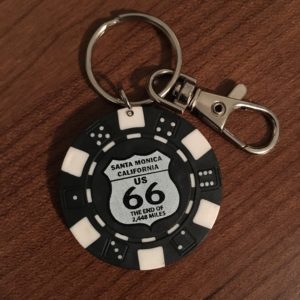 In photo. A poker chip with the shield of U.S. Route 66 attached as the charm on a key ring. End photo.
