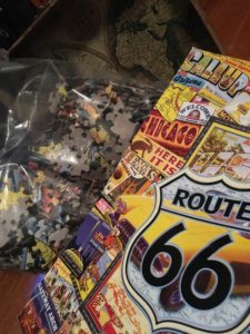 In photo. A puzzle of a marketing poster containing many photos and postcards with a U.S. Route 66 theme. End photo.