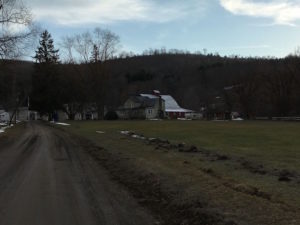 In photo the road to the lodge is muddy and the field is completely void of snow. 