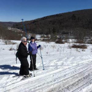 In photo Esther and Linda stand victoriously on the mountain with the lodge shown in the distance behind them.