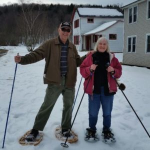 In photo Ed & Marilee on snowshoes pose side by side for the camera. 