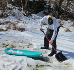 In photo. Ed is shoveling snow into a plastic sled. Not seen here is the fact that Barry and Louise also shared in covering the bare spots on Marty's Bump before a camera wielding guide appeared. Out of photo.