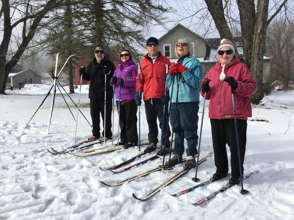 In photo. Carl, Raisa, Barry, Louise, and Marilee stand in their skis ready for a trek on the soccer field. Out of Photo.