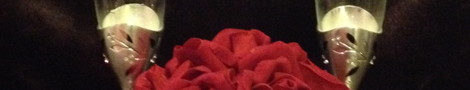 A slice of a photo revealing only a portion of a rose beauquet between two champagne flutes.