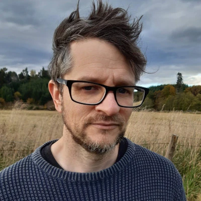 Seth in front of a field in NZ